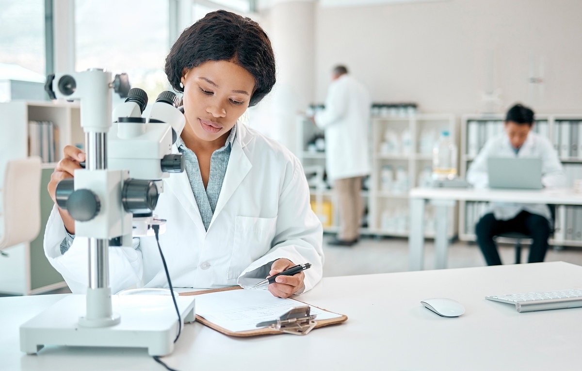 Researcher in a laboratory reviewing notes on EB-1A publications requirement for a green card petition