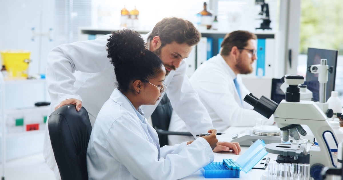 Research mentor guiding PhD student in lab, reflecting O-1 visa evidence for PhDs through critical role and collaboration